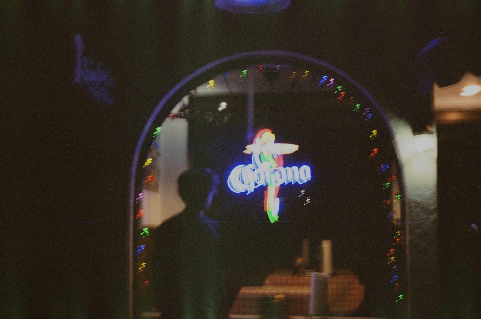 Person silhouetted against a glowing corona sign